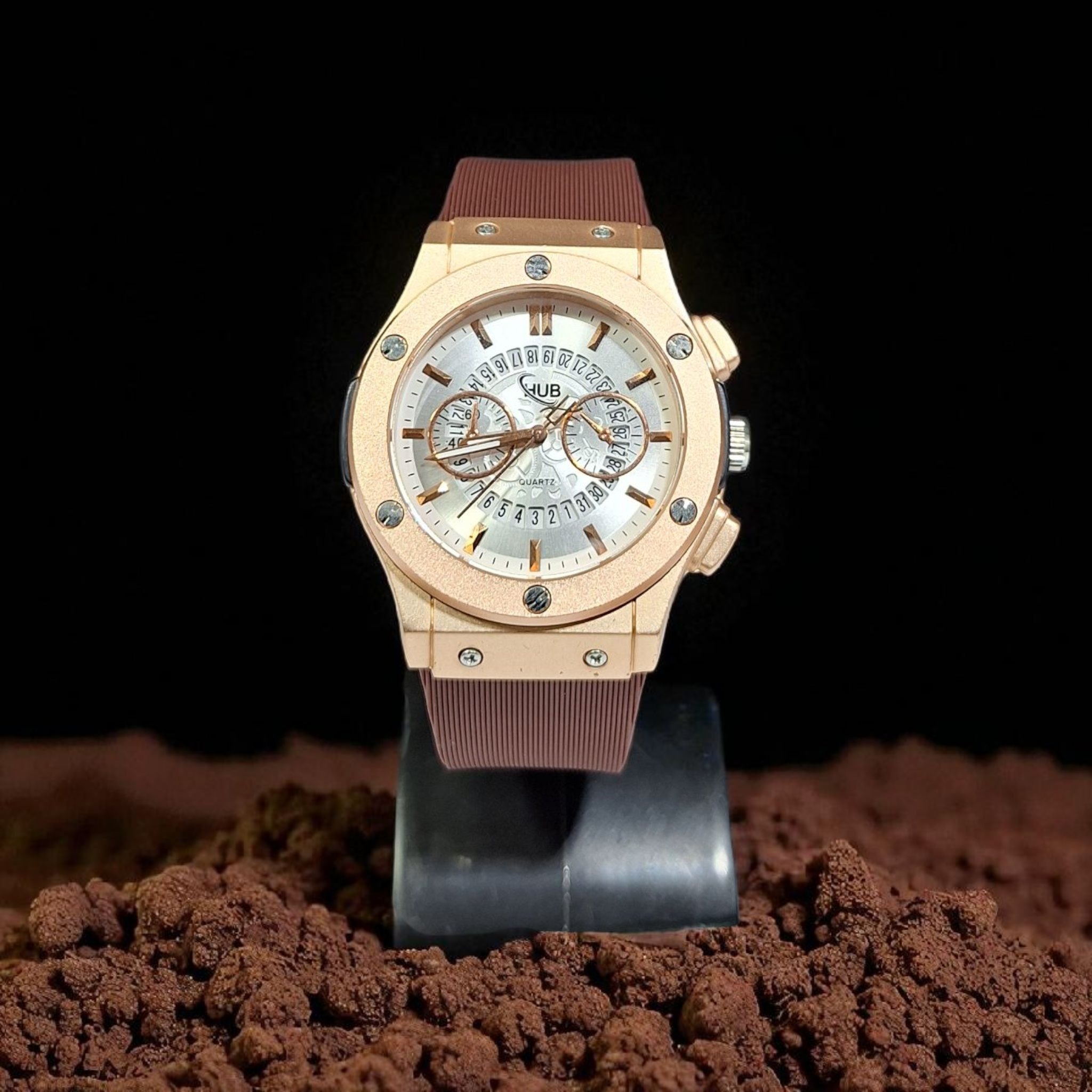 Gold watch with a brown strap on a dark background